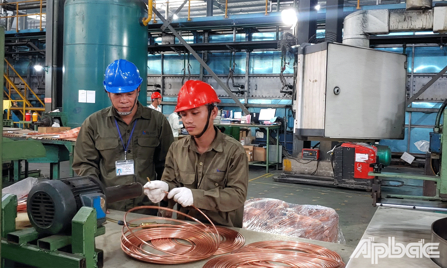 Kỹ sư Trần Văn Cưỡng (bên trái) giúp đỡ, kèm cặp, đào tạo, nâng cao tay nghề cho công nhân mới